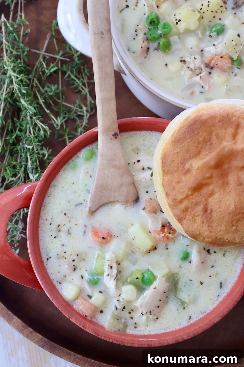 chicken pot pie soup in bowls, topped with a biscuit