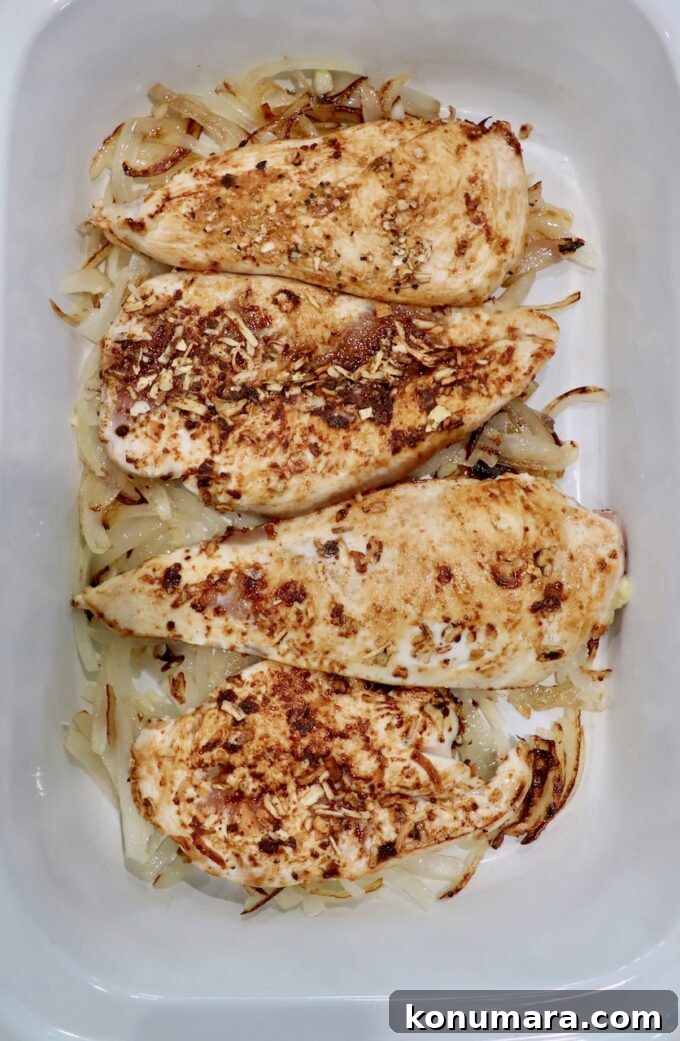 seasoned, seared chicken breasts in slow cooker with caramelized onions