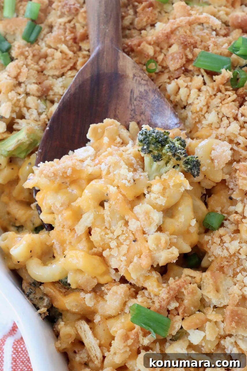 baked broccoli mac and cheese in casserole dish with large serving spoon
