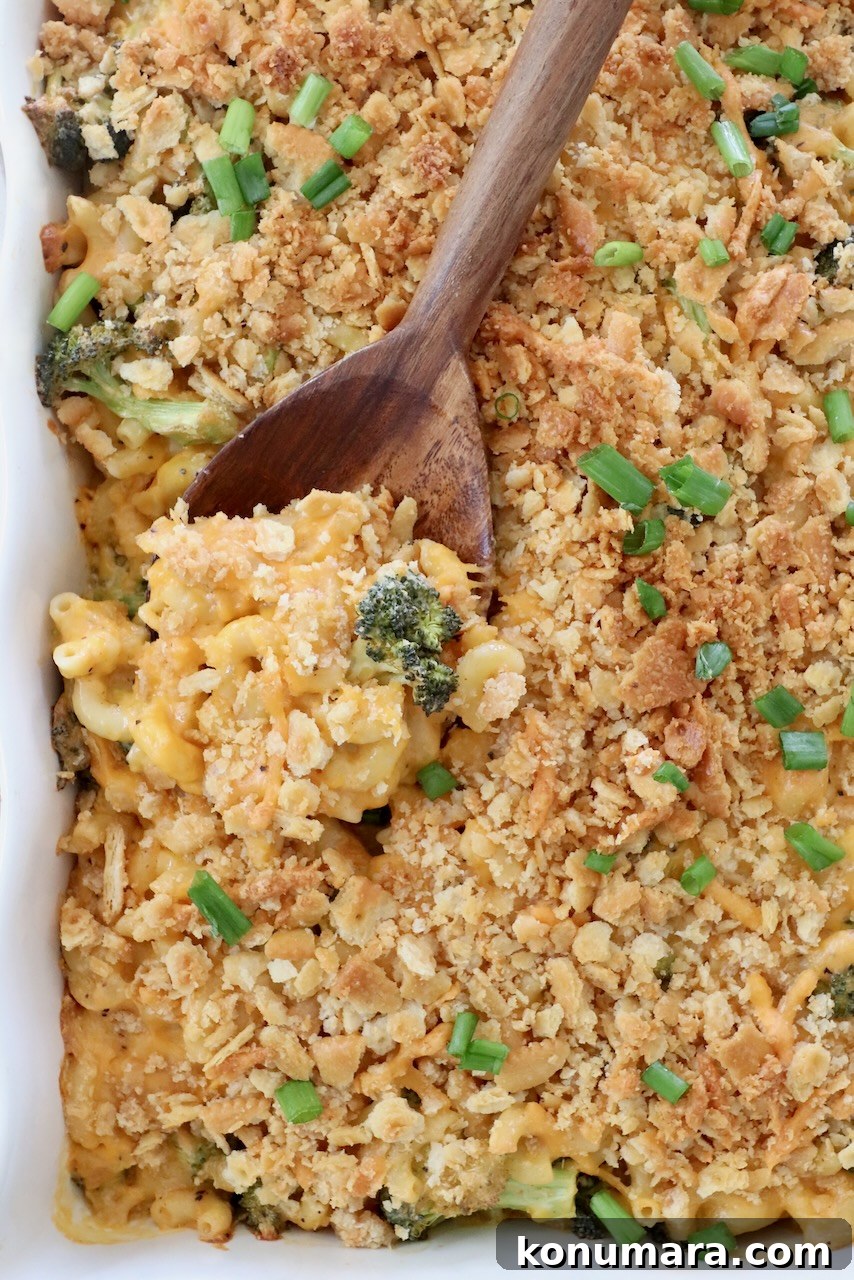 baked broccoli mac and cheese in casserole dish with serving spoon