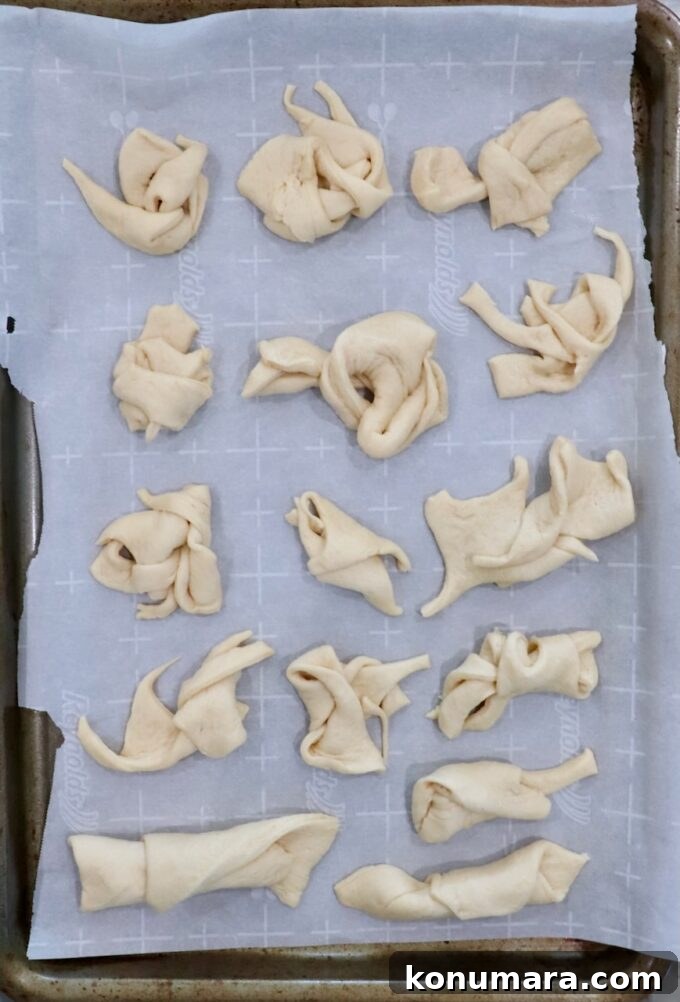 Mini Apple Pie Recipe: Cinnamon Hand Pies 7 leftover crescent roll dough scraps tied together on parchment-lined baking sheet