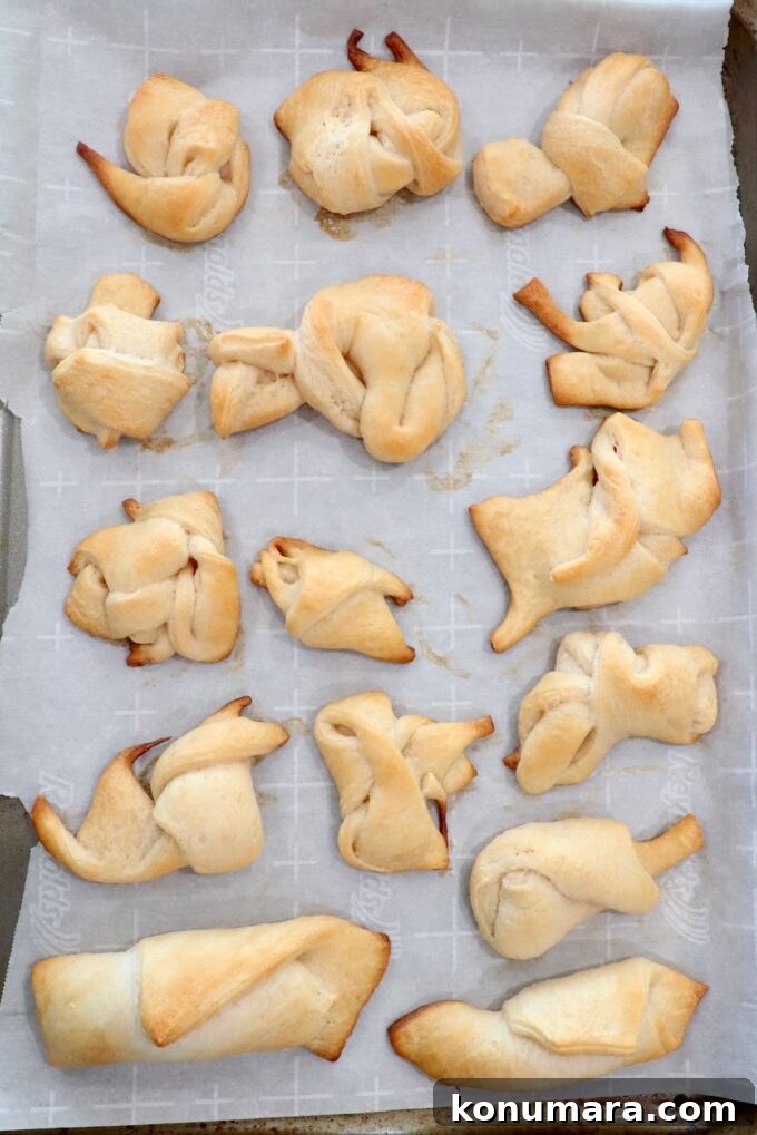 Mini Apple Pie Recipe: Cinnamon Hand Pies 8 baked crescent roll dough scraps tied together on parchment-lined baking sheet