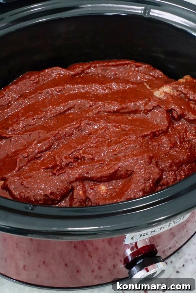 beef covered in tomato chili sauce in a crock pot