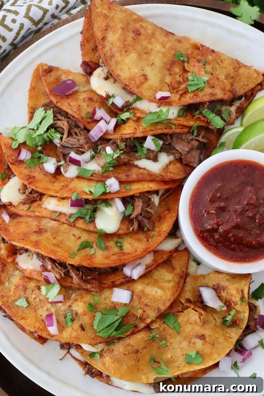 Quesabirria Recipe: Crispy Cheesy Birria Tacos 6 quesabirria tacos on plate with a side bowl of consomé