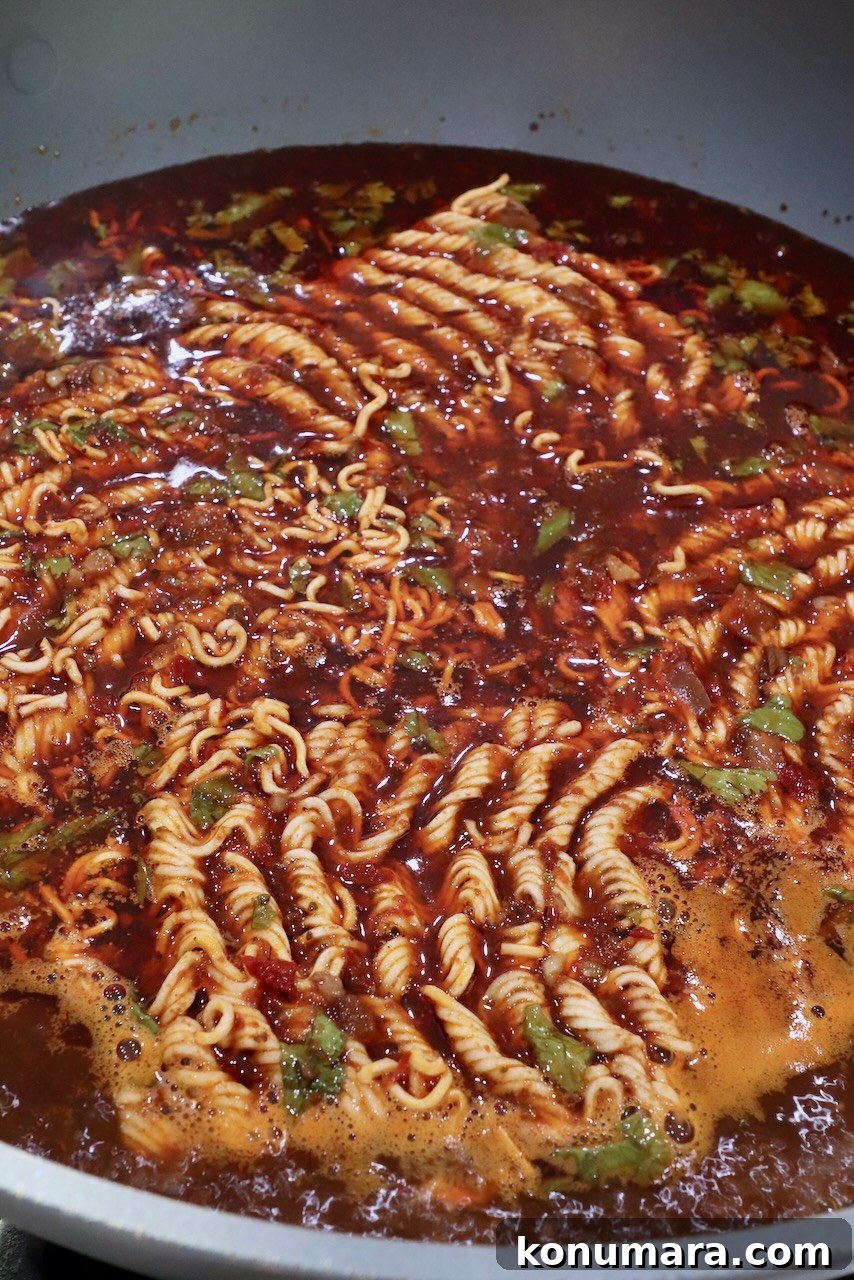 Instant ramen noodles in large pot of birria broth
