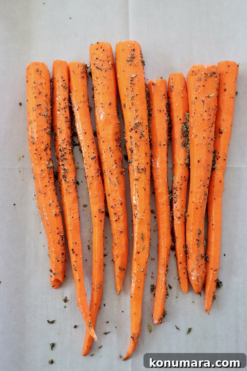 Oven-Roasted Carrots with Honey and Garlic 4 seasoned carrots on parchment lined baking sheet