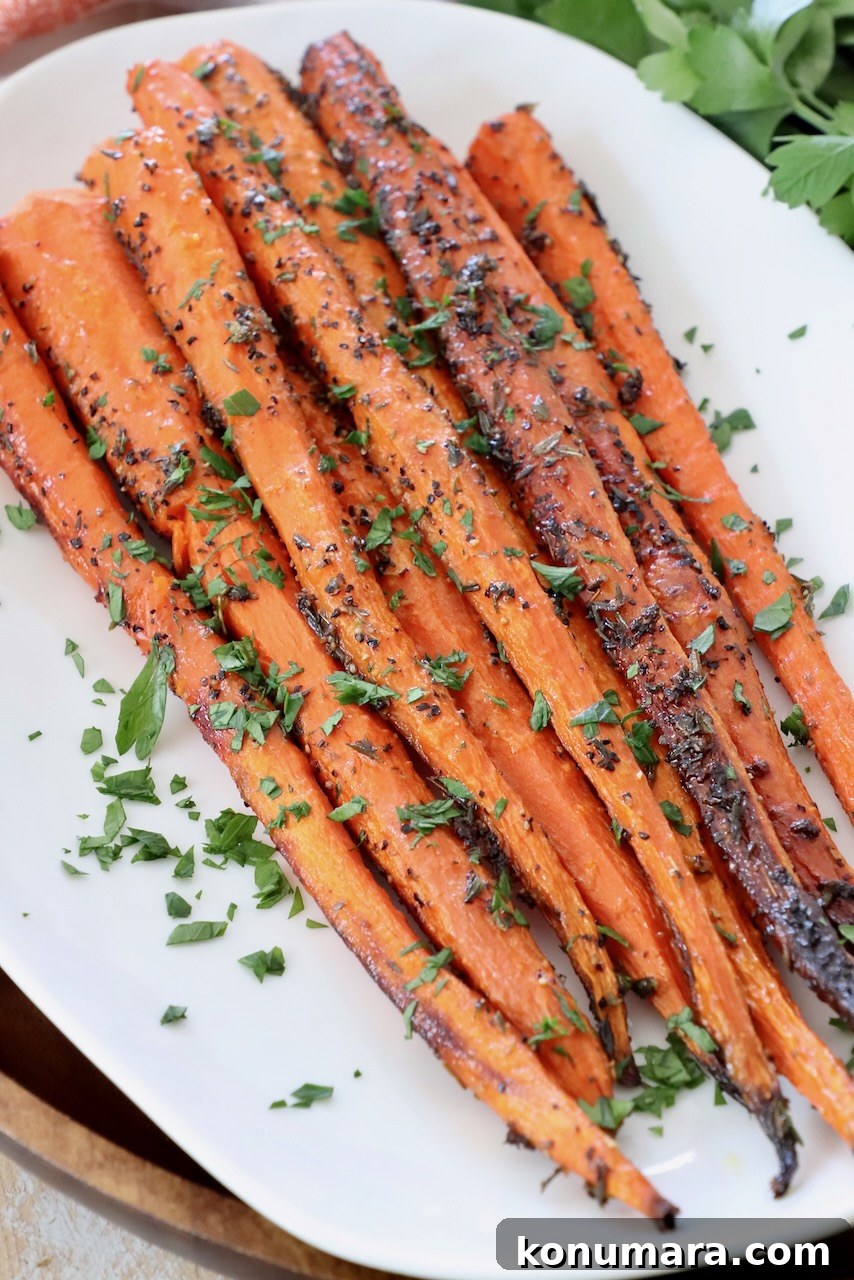Oven-Roasted Carrots with Honey and Garlic 5 roasted carrots on white plate