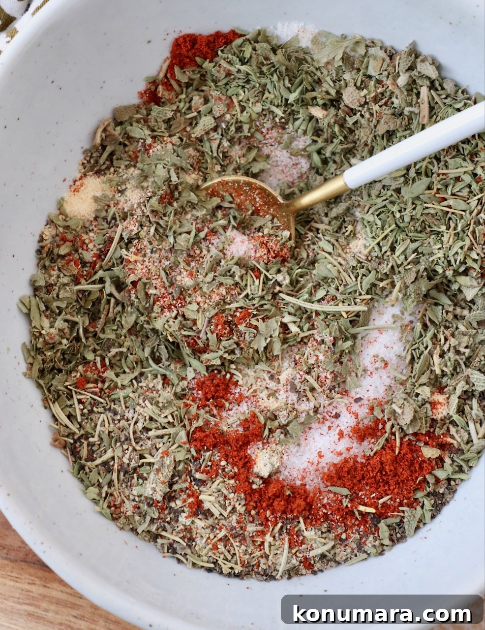 herbs and spices mixed together in bowl with a small spoon