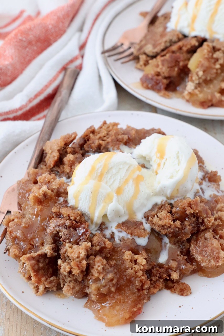 One-Pan Caramel Apple Dump Cake Recipe 8 baked caramel apple dump cake on plate with scoop of ice cream on top