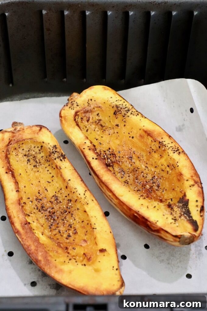 How to Cook Delicata Squash: Roast, Bake and Saute 10 seasoned cooked delicata squash sliced in half in air fryer basket