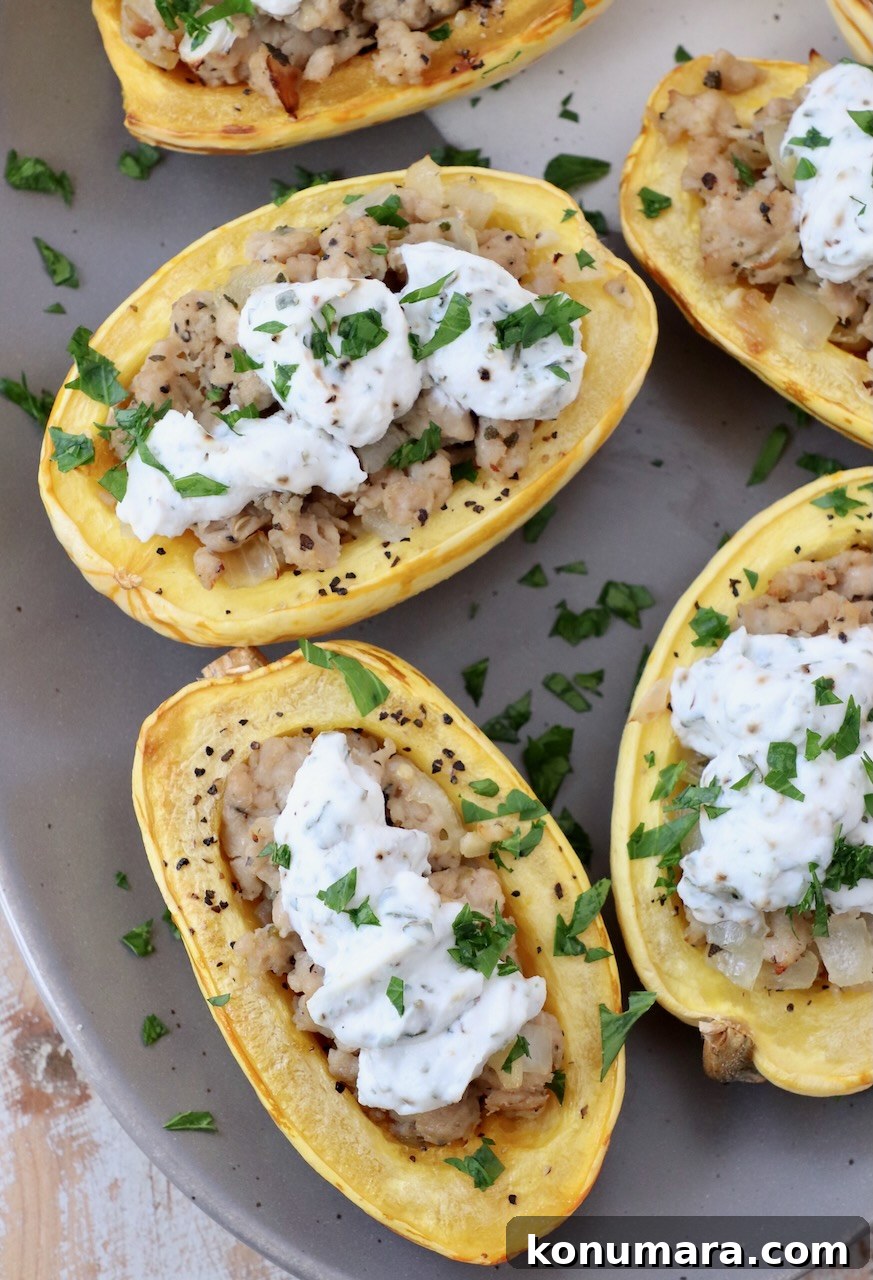 Roasted delicata squash filled with cooked sausage and ricotta cheese on a plate