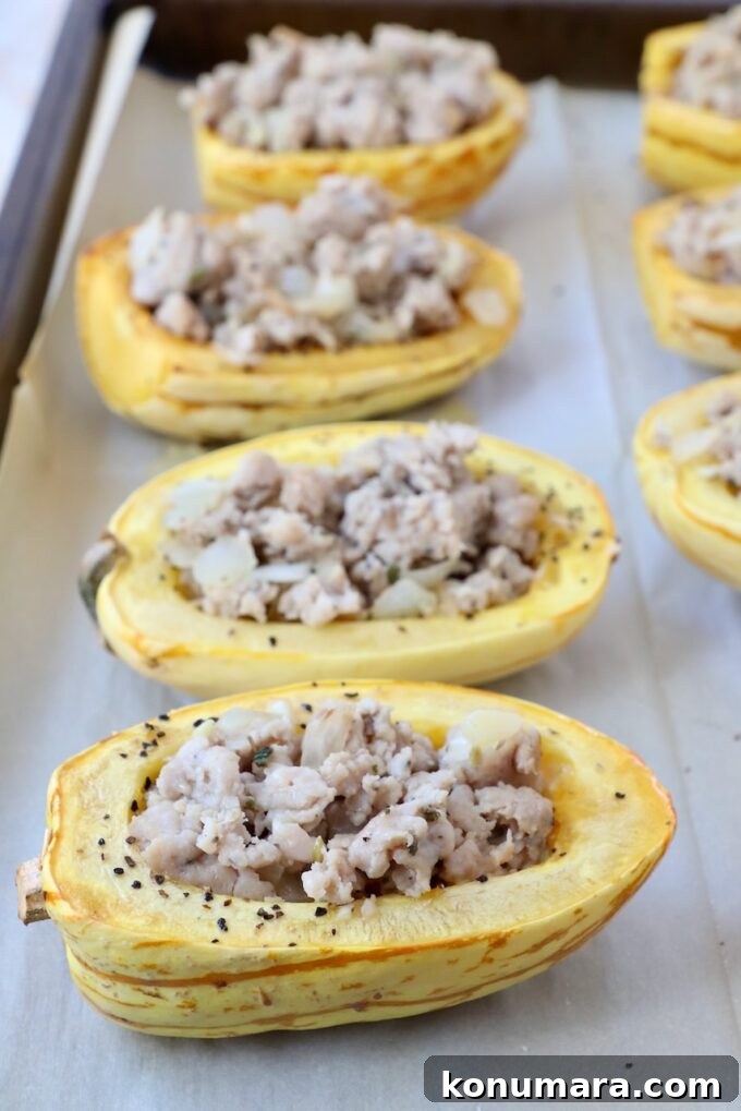Roasted delicata squash halves filled with cooked ground sausage