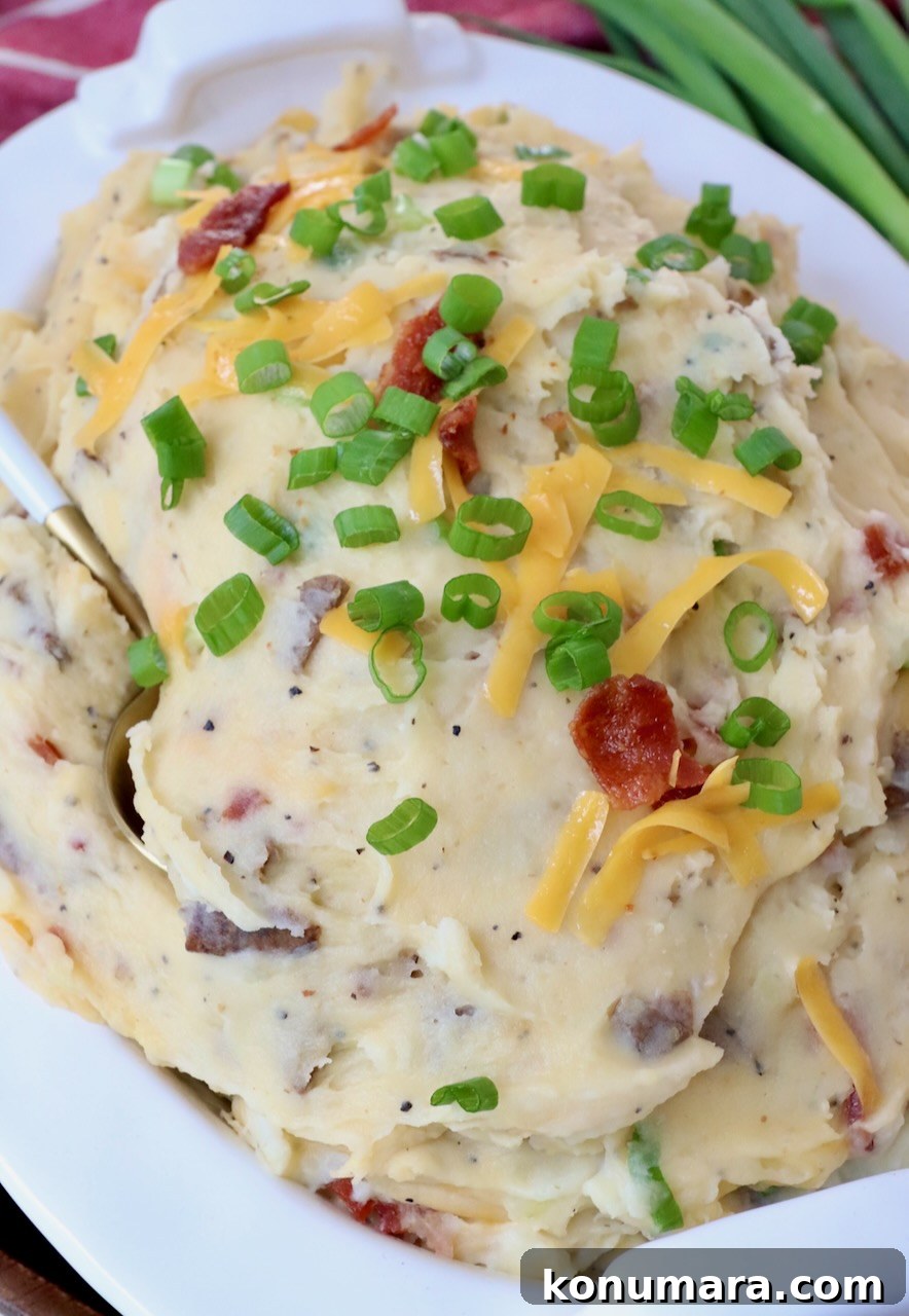 Loaded Mashed Potatoes Recipe with Bacon and Cheddar 7 loaded mashed potatoes in serving dish with spoon