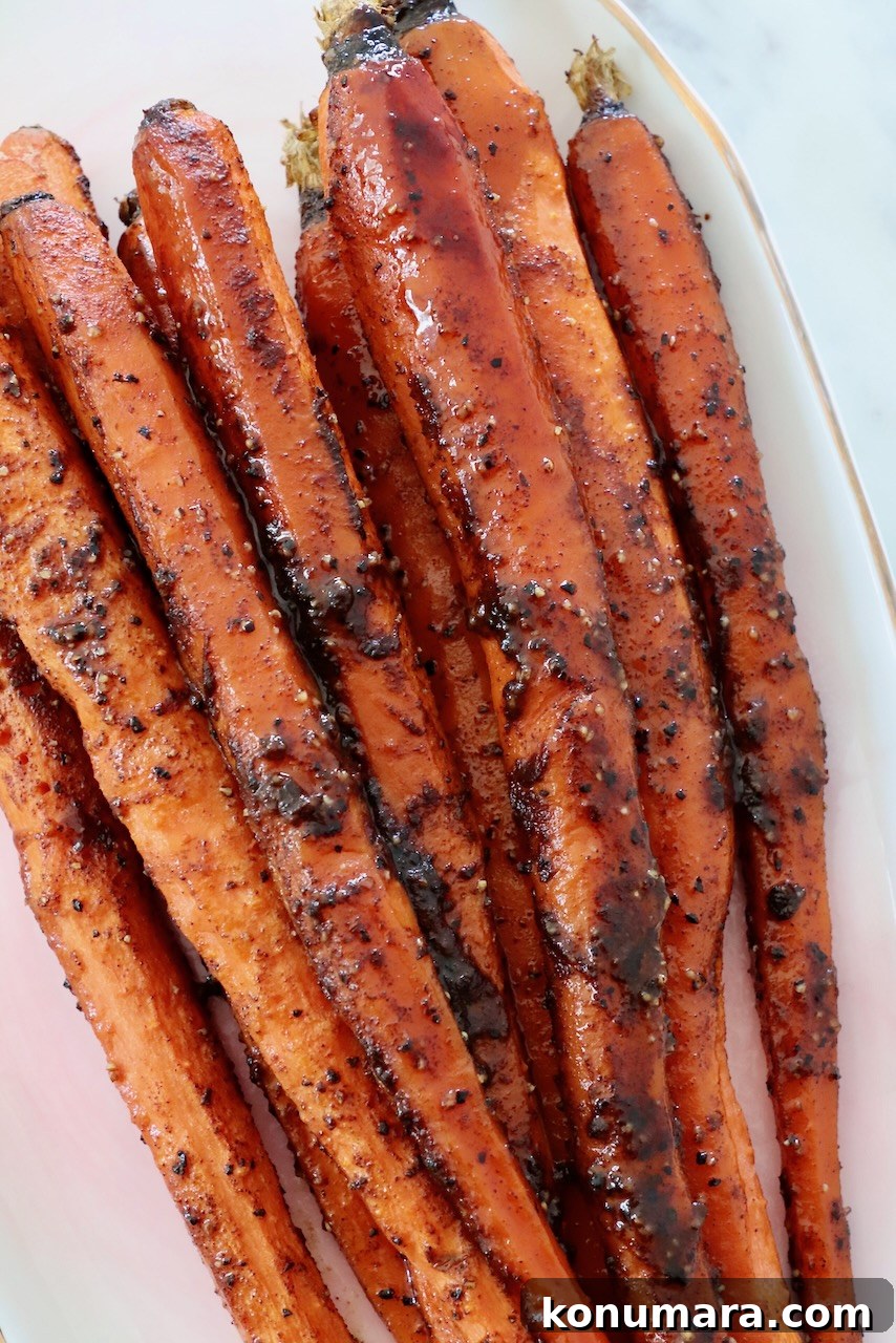 Honey-Glazed Carrots with Thyme and Garlic 2 roasted, seasoned carrots on plate