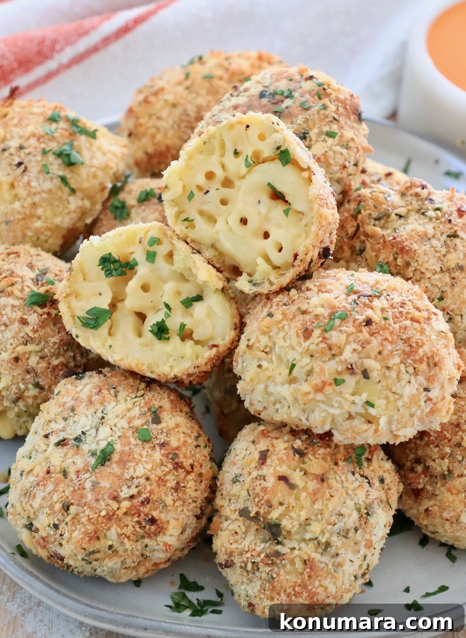 breaded balls of mac and cheese stacked up on a plate