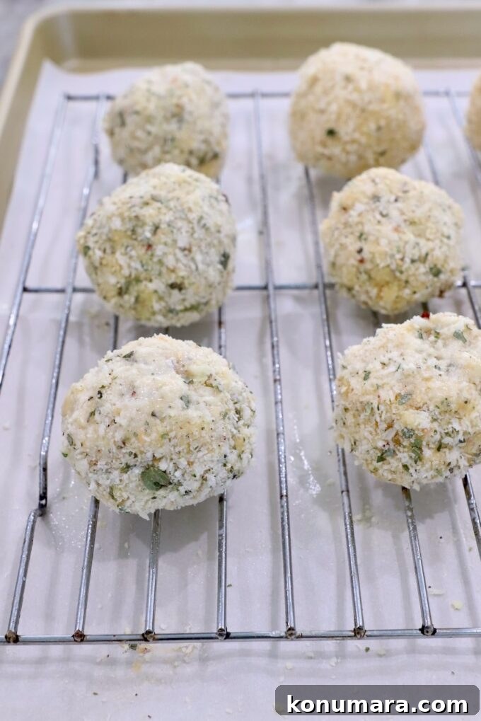 breaded mac and cheese balls on wire rack on top of a baking sheet
