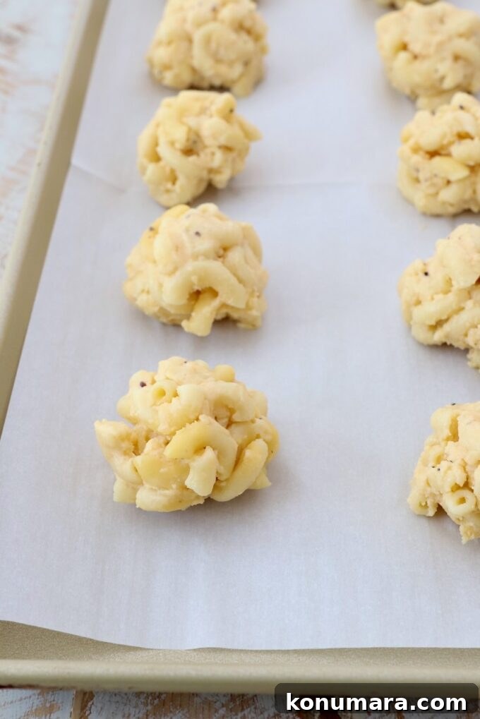 balls of mac and cheese on parchment lined baking sheet