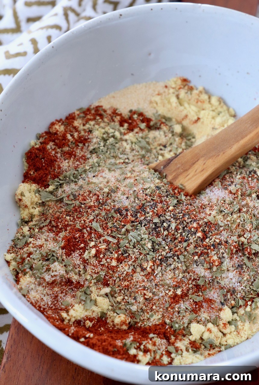 herbs and spices mixed together in bowl with wooden spoon