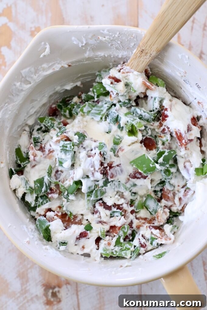 cream cheese, combined with blue cheese, chopped bacon and diced green onions in a bowl