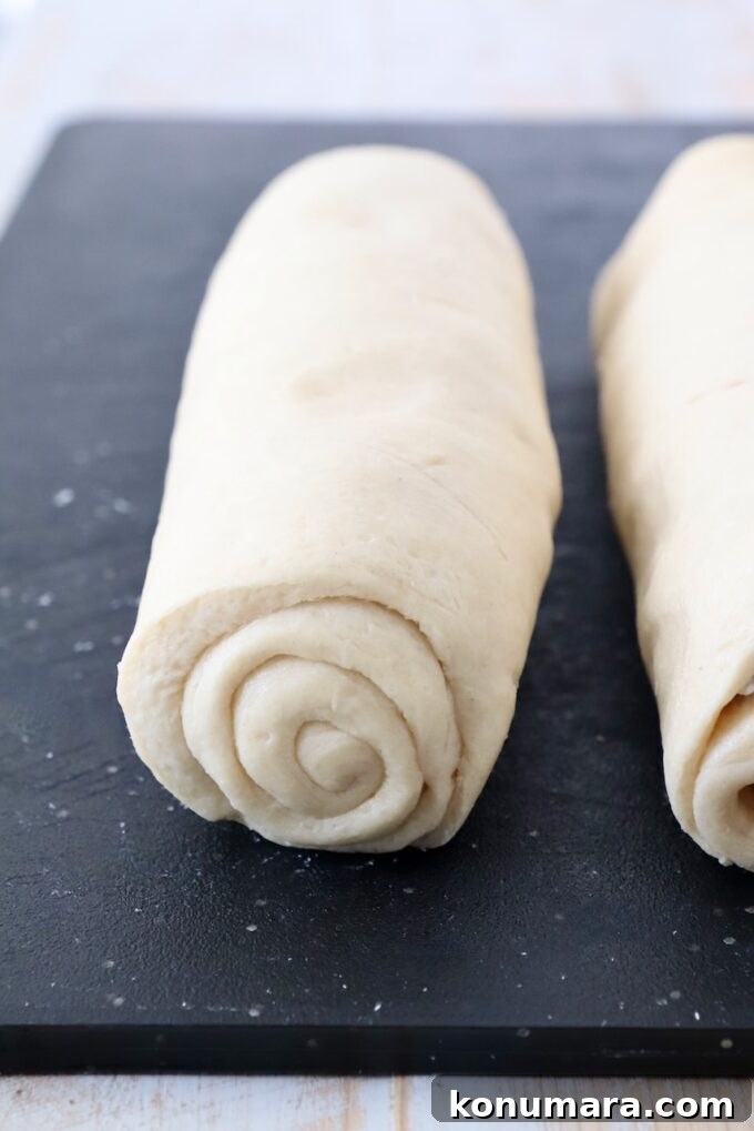 crescent roll dough rolled up on cutting board