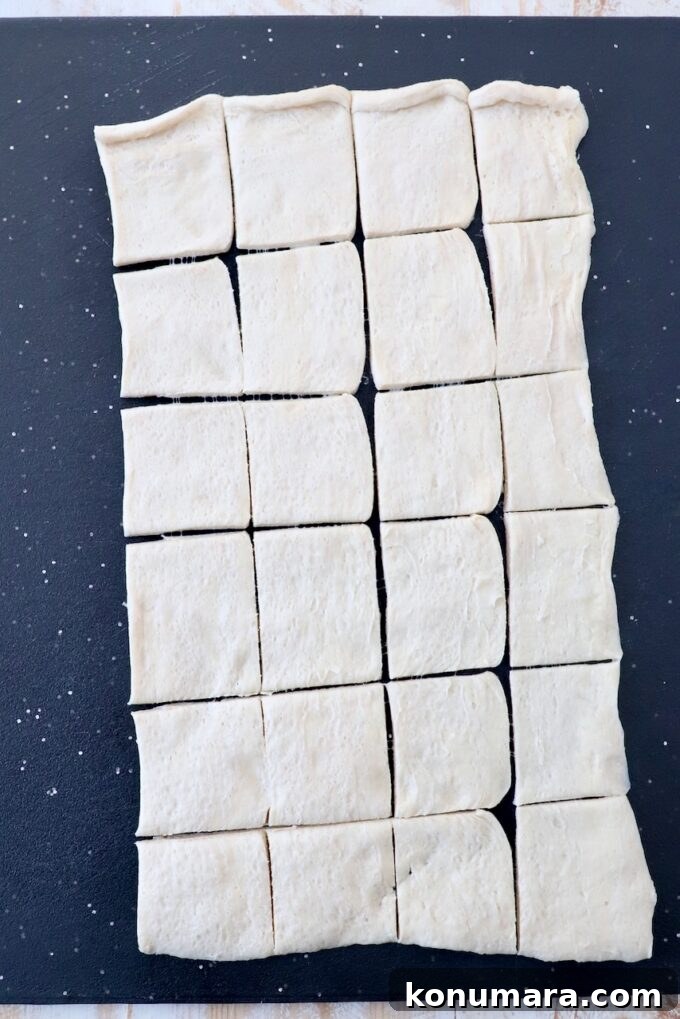Cranberry Brie Bites Recipe with Puff Pastry 4 crescent roll dough on cutting board cut into 24 small squares