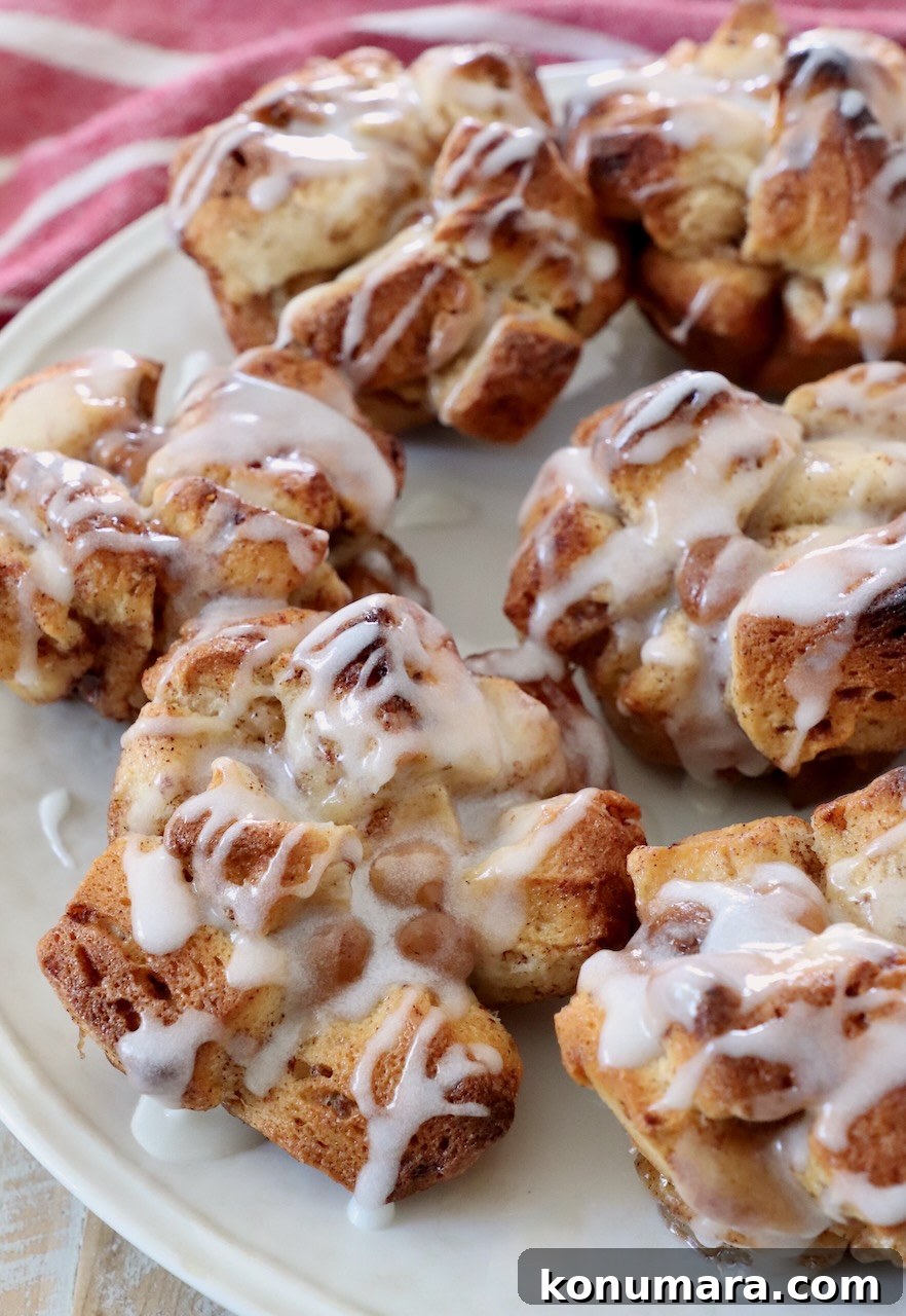 pull apart cinnamon rolls drizzled with cream cheese icing on plate