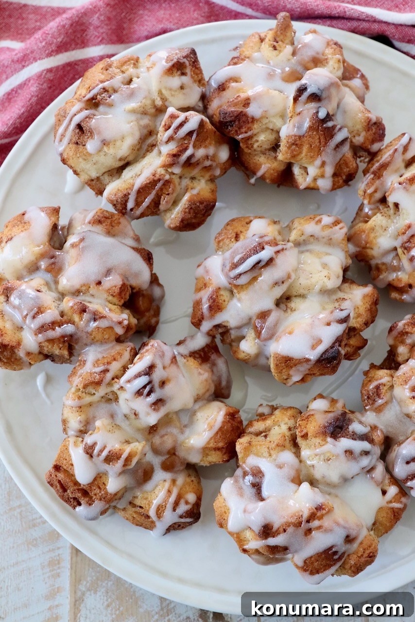pull apart cinnamon rolls on plate drizzled with cream cheese icing