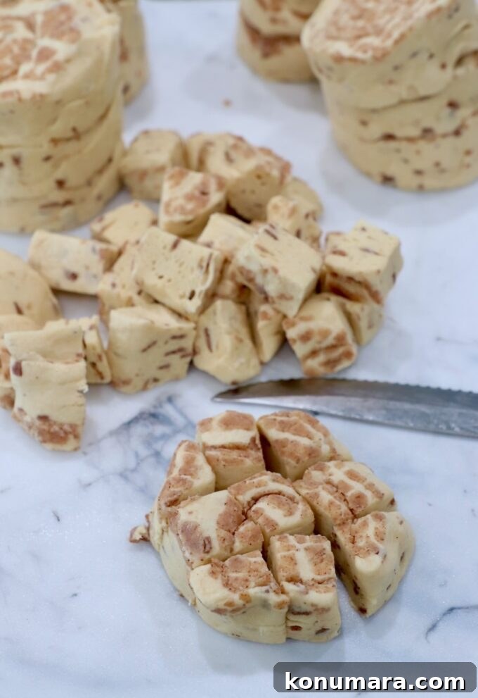 refrigerated canned cinnamon rolls being diced up on a cutting board