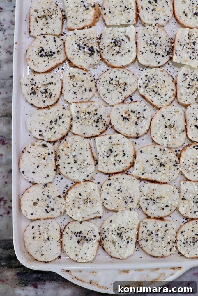 Crispy Homemade Bagel Chips: Recipe and Flavor Ideas 5 seasoned sliced bagel chips on baking sheet