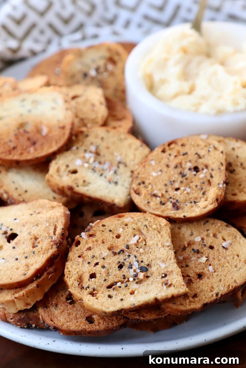 Crispy Homemade Bagel Chips: Recipe and Flavor Ideas 7 bagel chips on plate with cheese spread in a small bowl