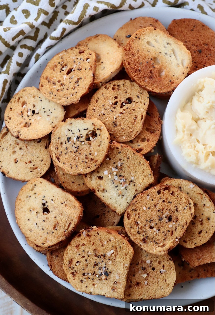 Crispy Homemade Bagel Chips: Recipe and Flavor Ideas 8 everything bagel chips on plate with cheddar cheese spread in a small bowl