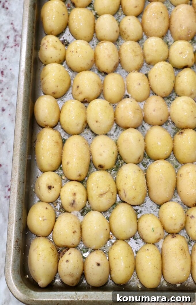 baby potatoes sliced in half on baking sheet