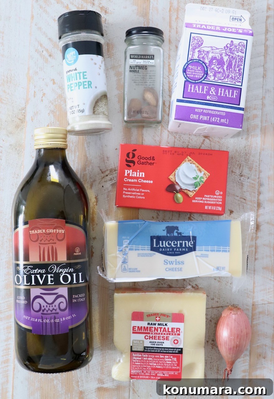 ingredients for cheese fondue on white wood board