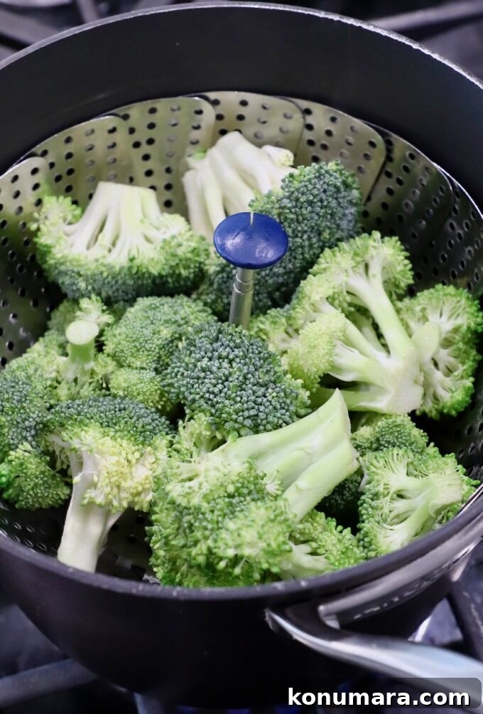 broccoli florets in steamer basket in pot on the stove