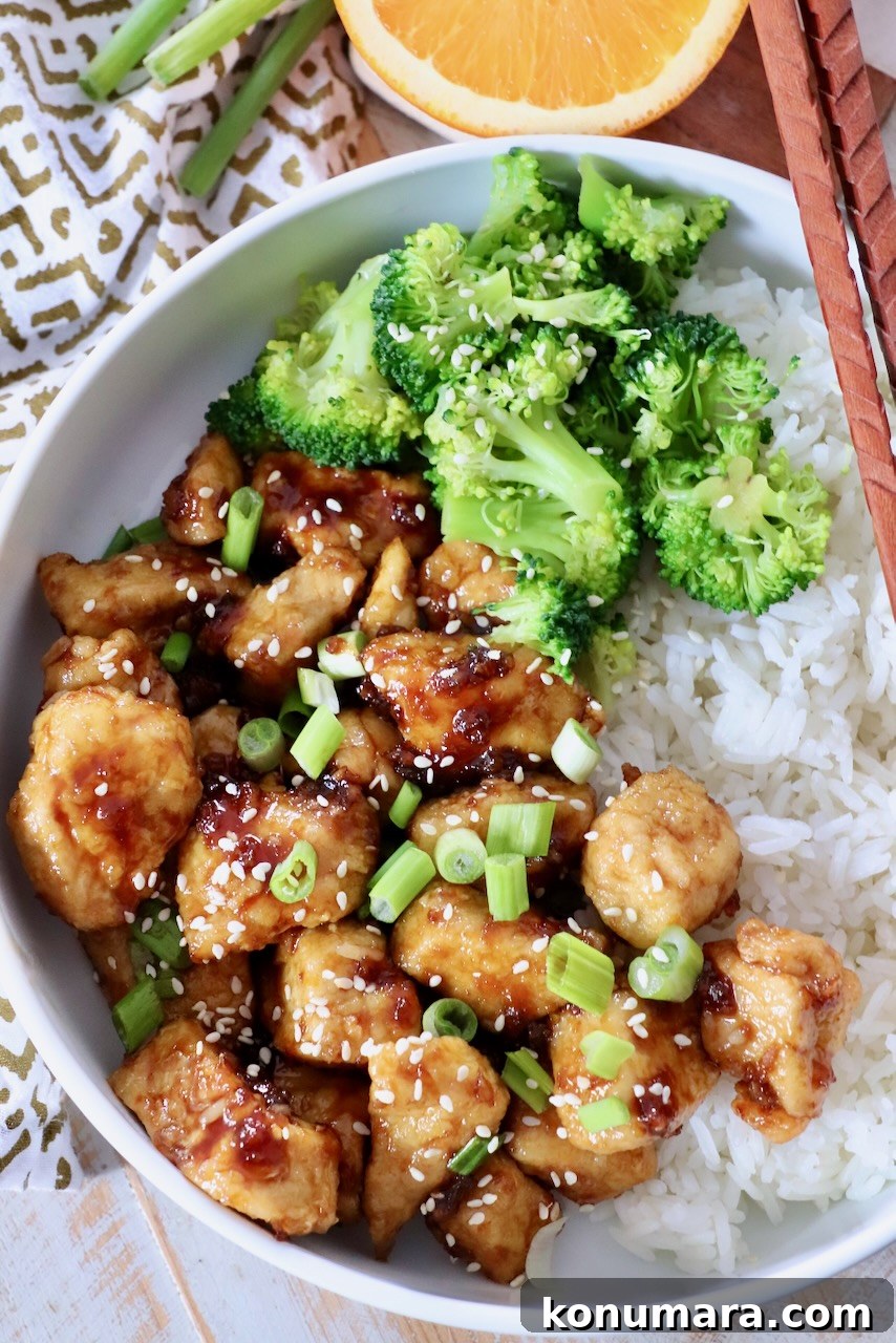 steamed broccoli and orange chicken in bowl with white rice