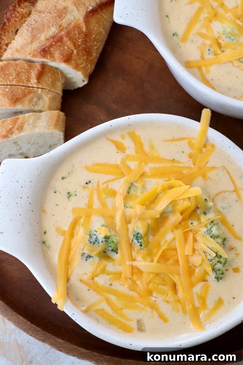 shredded cheddar cheese on top of broccoli cheddar soup in bowl