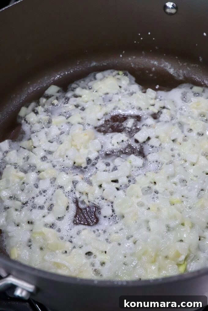 diced onions and garlic cooking with cornstarch in pot