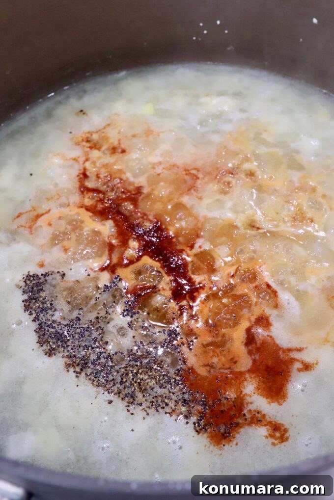 seasoned chicken broth in pot with diced onions