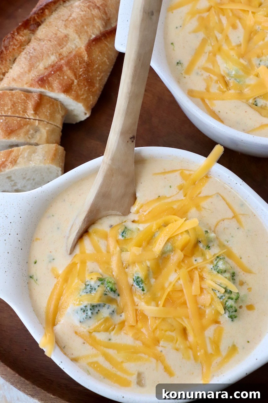 broccoli cheddar soup in bowl with wooden spoon