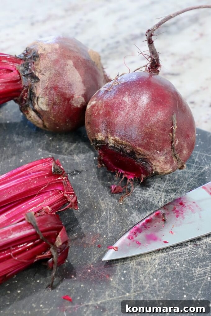 How to Cook Beets: Roast, Boil, and Sauté 3 raw beets on cutting board with the stems cut off