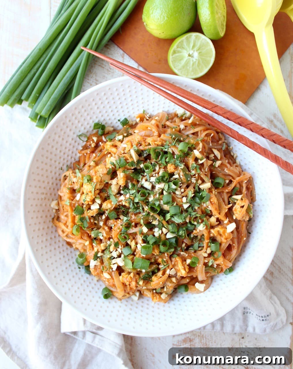 prepared pad thai in bowl with chopsticks on the side of the bowl