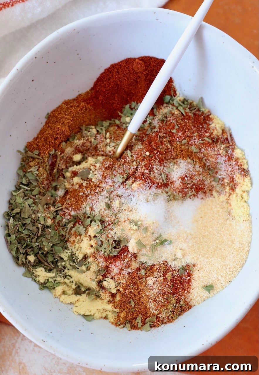 spices and dried herbs mixed together in bowl with spoon