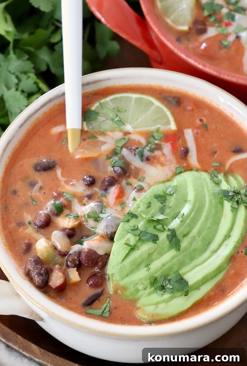 black bean soup in bowl topped with sliced avocado