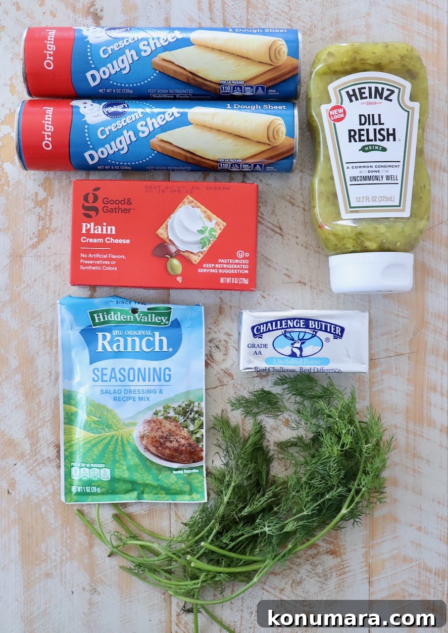 ingredients for creamy pickle roll ups on white wood board