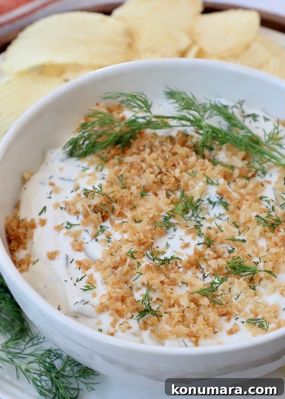 Dill pickle dip in bowl topped with toasted breadcrumbs