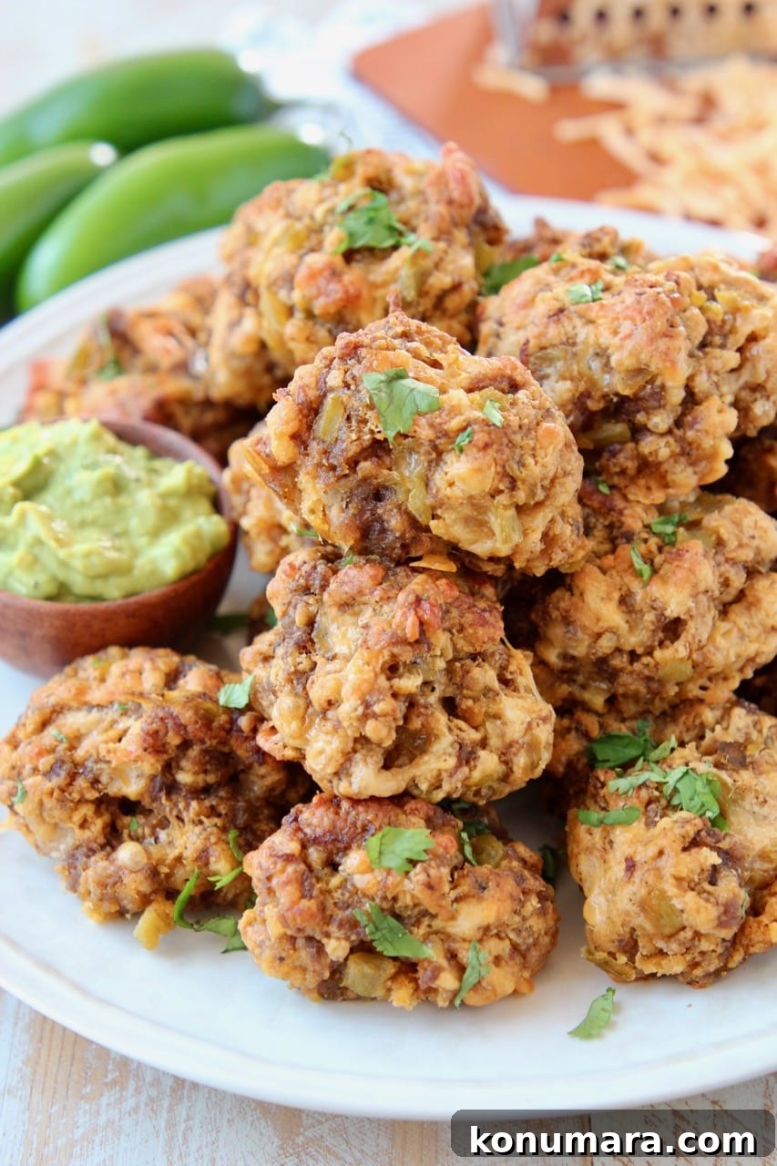 Cheesy Mexican Sausage Balls Recipe with Jalapeno 2 sausage balls piled up on plate with small bowl of avocado dipping sauce