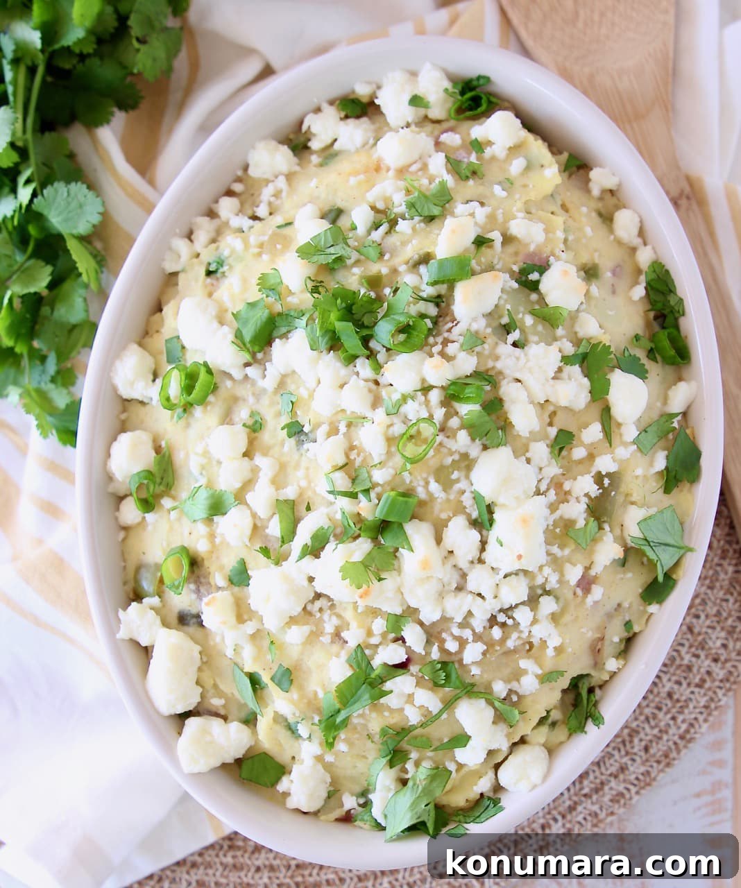 Bowl of mashed potatoes topped with queso fresco, cilantro and green onions
