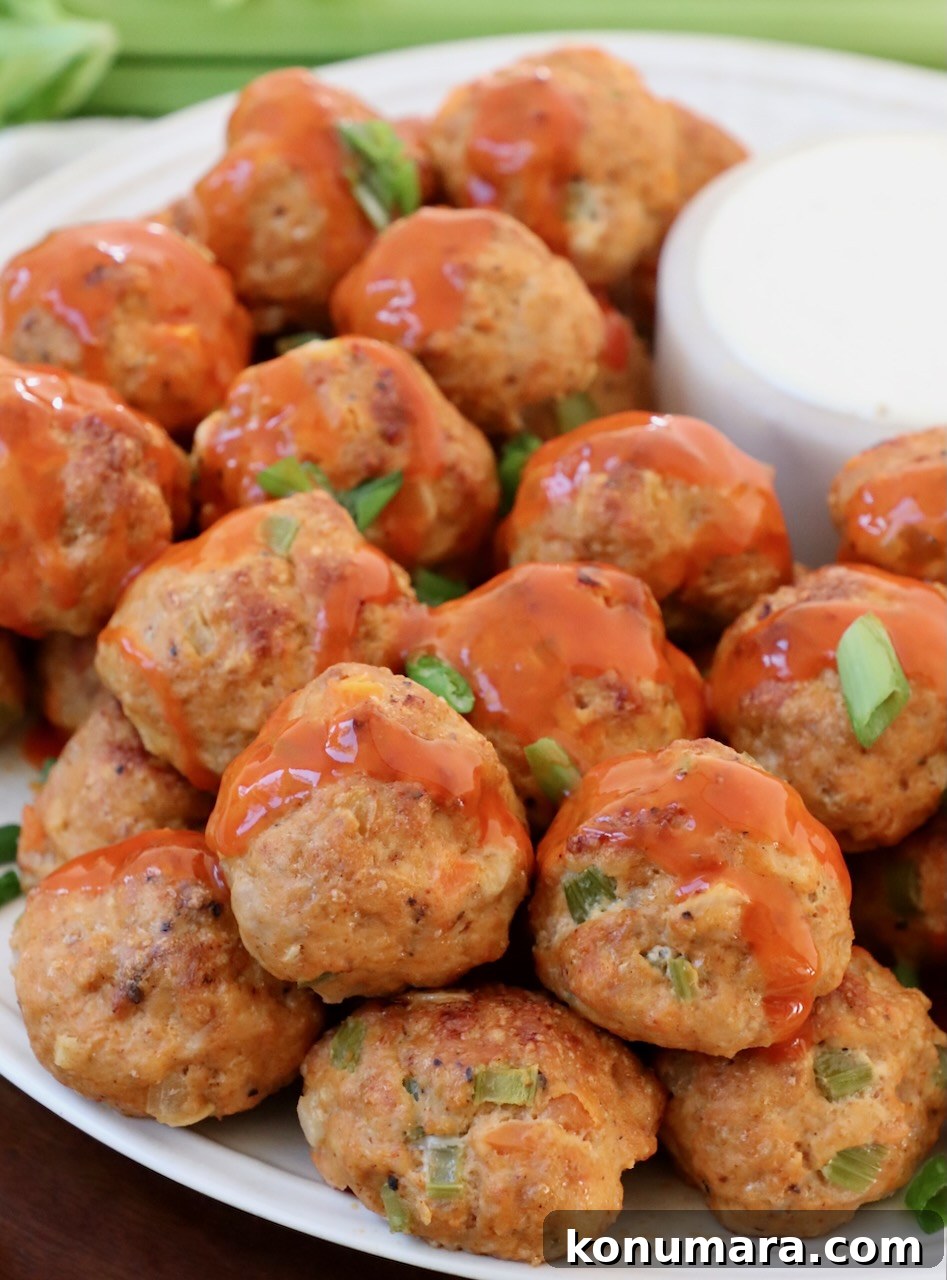 meatballs on plate drizzled with buffalo sauce
