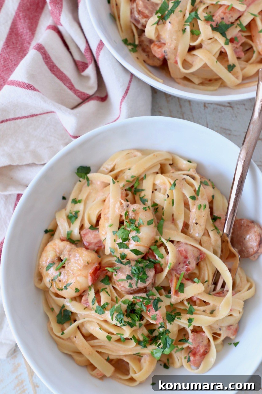 Creamy Cajun Shrimp Pasta with Andouille Sausage 10 overhead image of cajun shrimp pasta in white bowls with fork