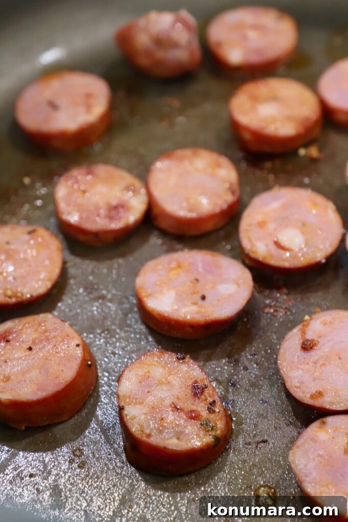 Creamy Cajun Shrimp Pasta with Andouille Sausage 5 sliced sausage cooking in pan